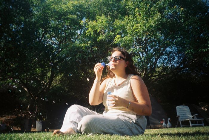 Anneme blowing bubbles on a sunny day taken on a film camera